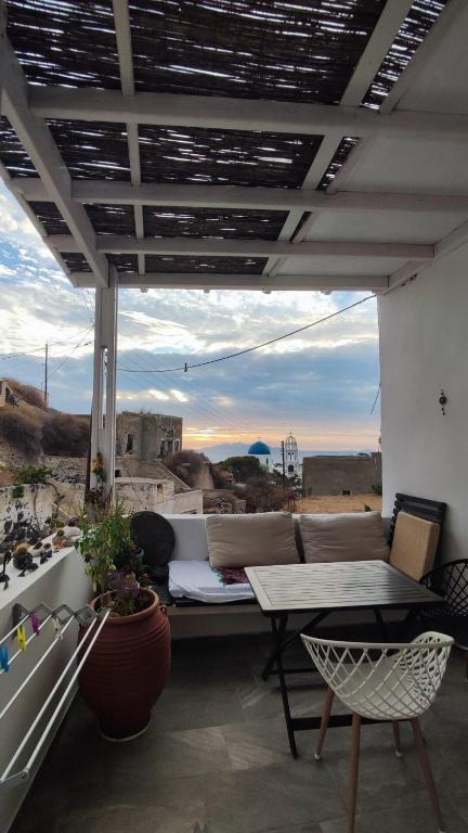 a patio with a table and a view of the desert at Mythos Traditional Stonehouse in Kamari