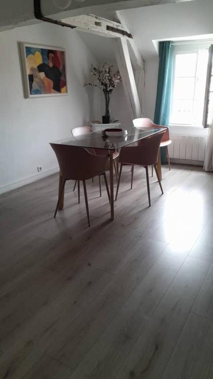 une salle à manger avec une table et des chaises dans une pièce dans l'établissement ALEIDA, à La Rochelle
