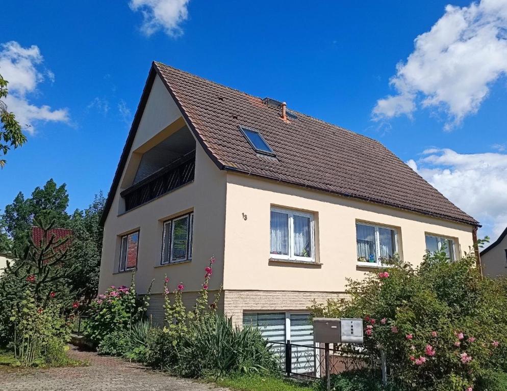 ein Haus mit einem braunen Dach und einigen Büschen in der Unterkunft Ferienappartement in Lauterbach auf Rügen! in Lauterbach