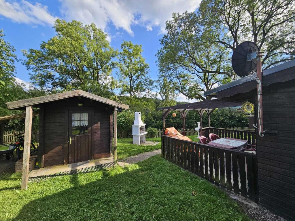 a backyard with a wooden fence and a gazebo at Ferienhaus Waldgefluester in Nausis