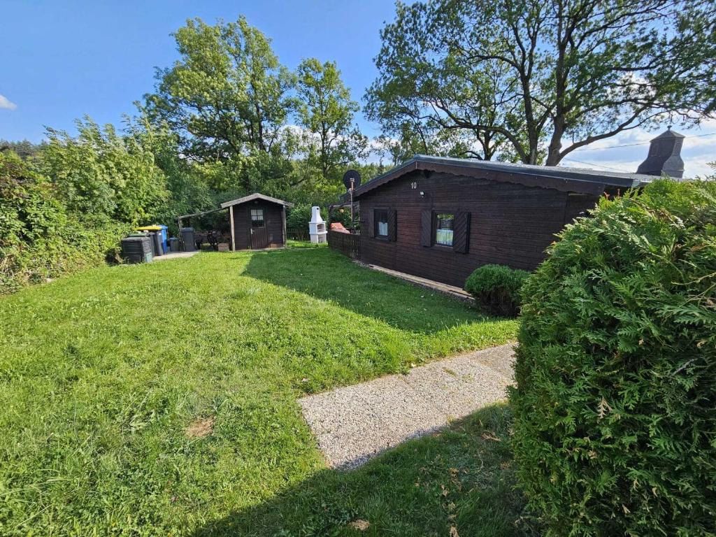 a small cabin in a yard next to a yard at Ferienhaus Waldgefluester in Nausis