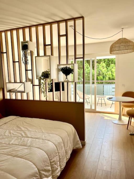 - une chambre avec un lit et une vue sur une terrasse dans l'établissement Studio calme avec vue sur un grand Pin parasol, à Cannes
