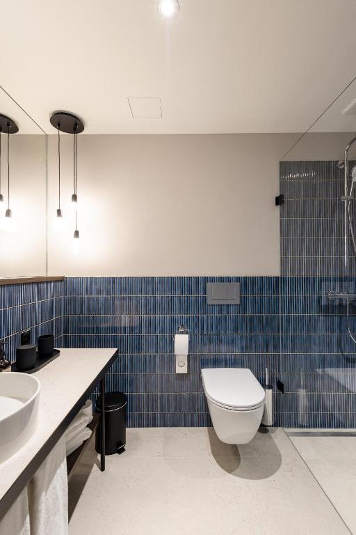 a bathroom with a toilet and a sink and a tub at The Yarn in Horgen