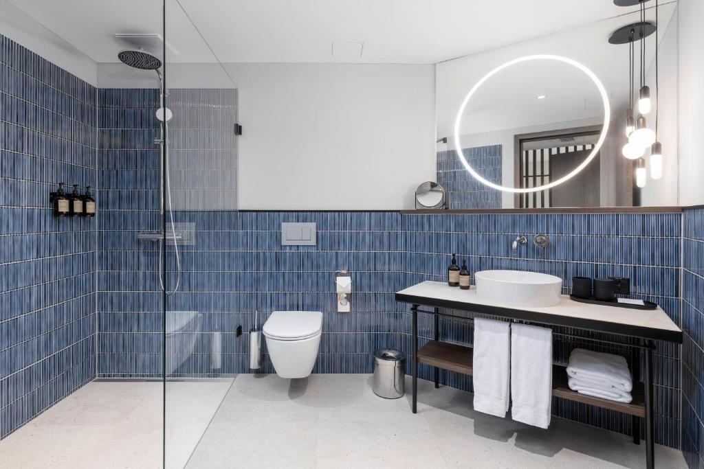 a bathroom with a sink and a toilet and a mirror at The Yarn in Horgen