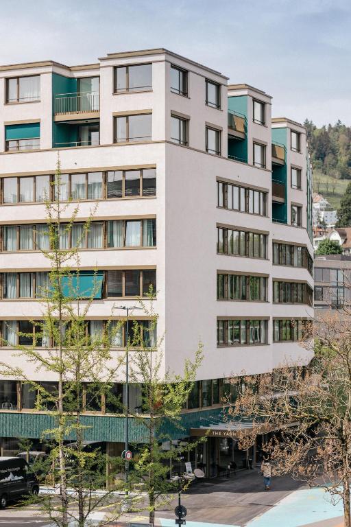 a tall white building with trees in front of it at The Yarn in Horgen