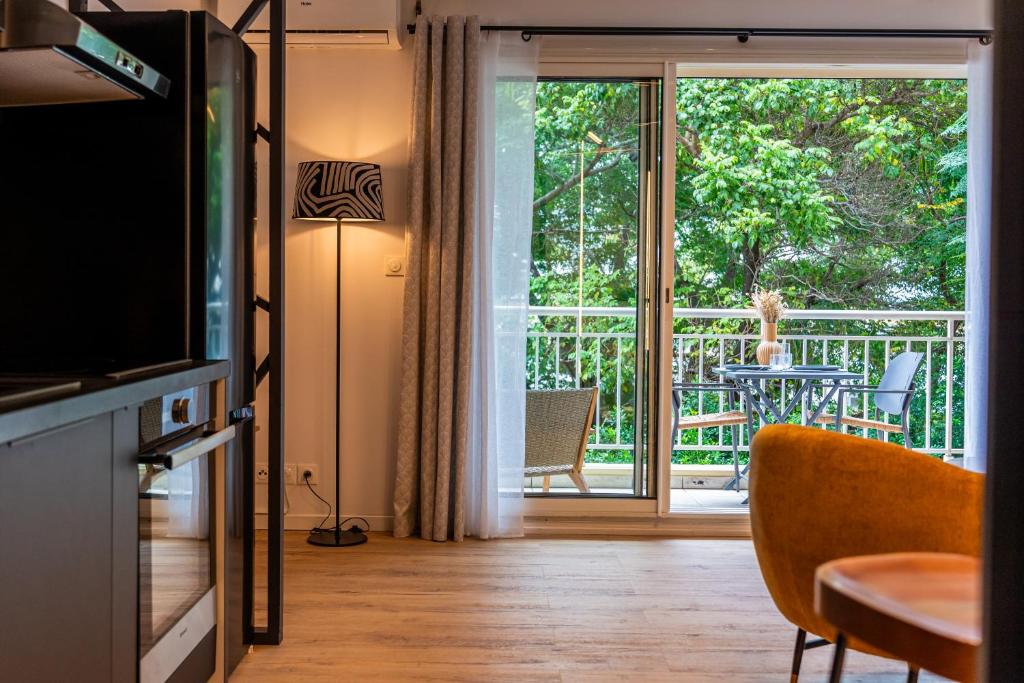 a living room with a television and a sliding glass door at Studio-St Pierre centre proche toutes commodités in Saint-Pierre