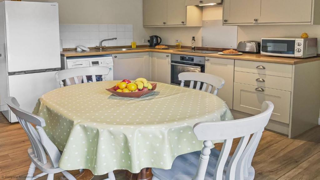a kitchen with a table with a bowl of fruit on it at Whitedown in Alton