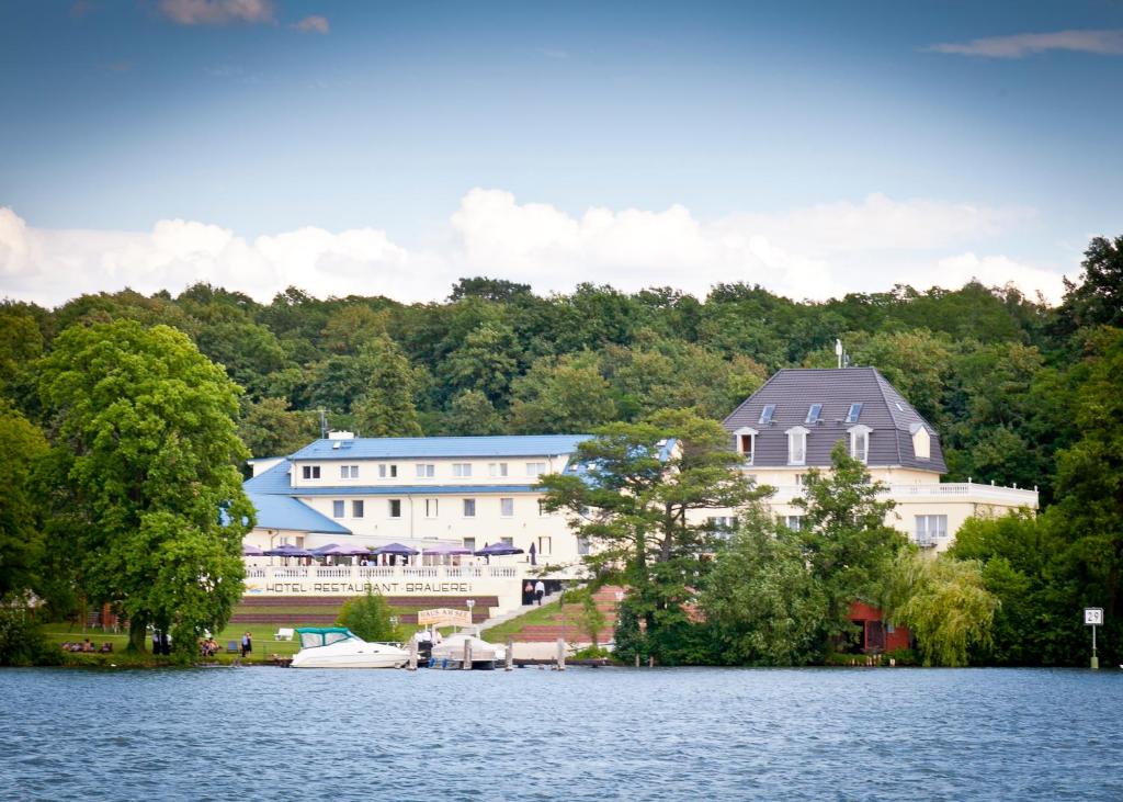 un groupe de bâtiments sur la rive d'un lac dans l'établissement Hotel Resort Märkisches Meer, à Diensdorf-Radlow