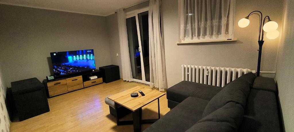 a living room with a couch and a flat screen tv at Apartament Opawska in Racibórz