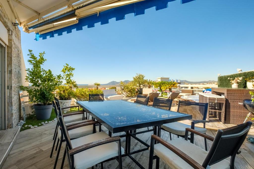 un patio avec une table et des chaises bleues dans l'établissement Sea and Sky 8 personnes, à Cannes