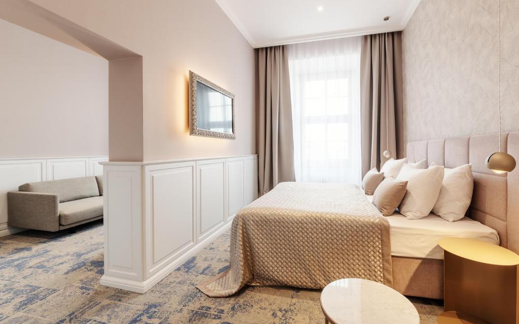 a hotel room with a bed and a couch at Grandhotel Brno in Brno