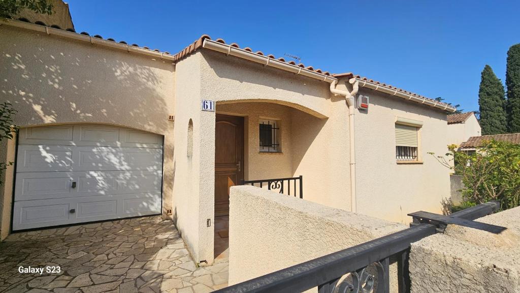 une maison avec une porte de garage et une clôture dans l'établissement Unique ! Montpellier proche centre Maison avec jardin, à Montpellier