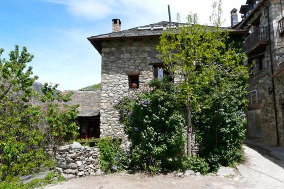 une maison en pierre avec des arbres devant elle dans l'établissement Casa Independiente Rural Ca de Corral, à Taull