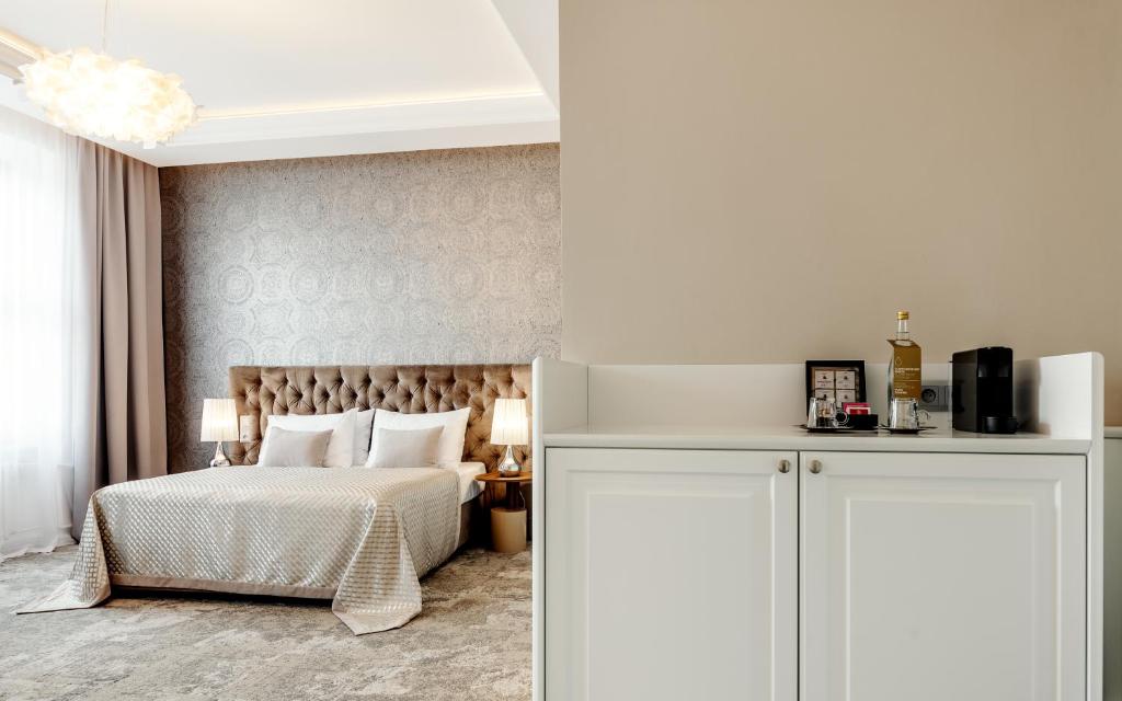 a bedroom with a white bed and a white cabinet at Grandhotel Brno in Brno