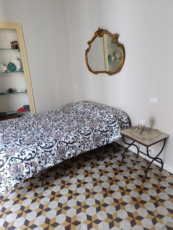 Un dormitorio con una cama, un espejo y una mesa. en La dimora del MARCHESE NOTARBARTOLO, en Palermo