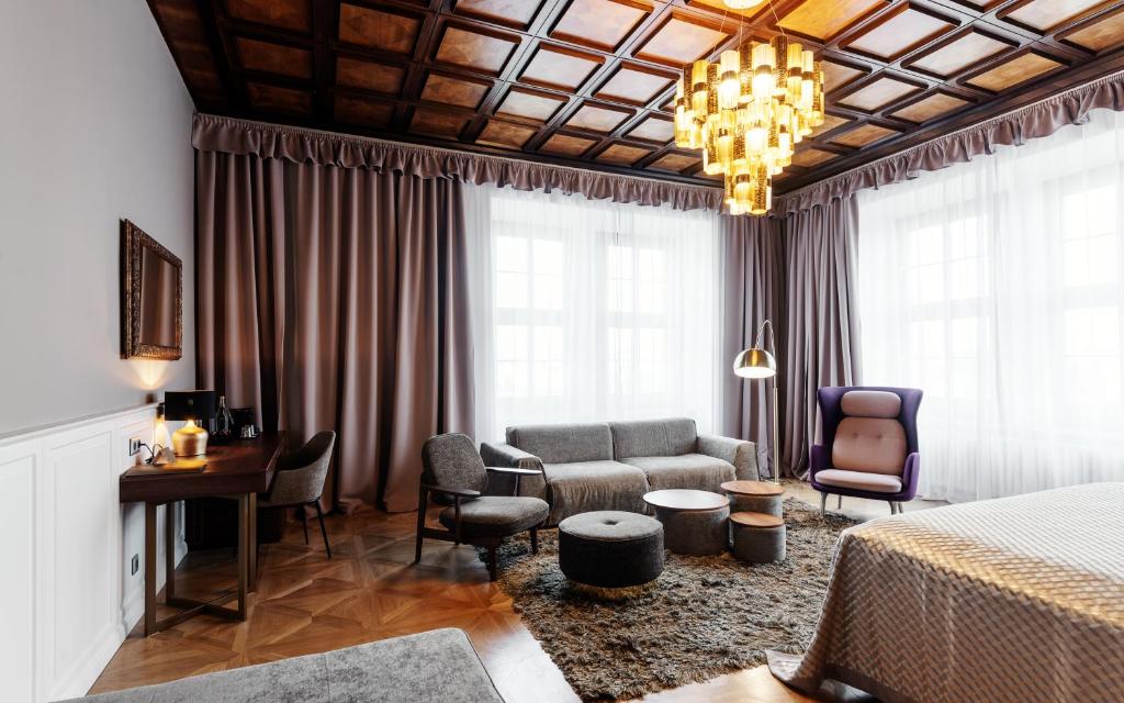 a hotel room with a bed and a couch and chairs at Grandhotel Brno in Brno