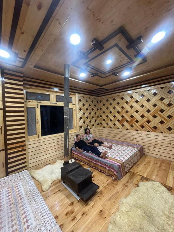 two people sitting on a bed in a room at Janvi Homestay in Kalpa