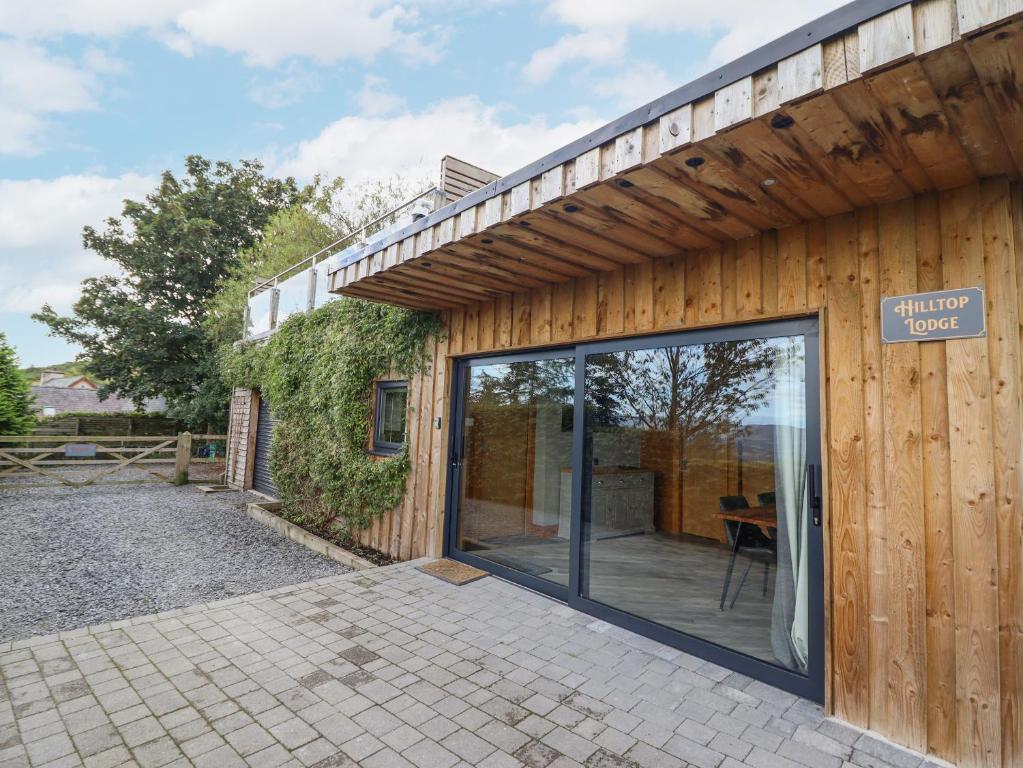un edificio in legno con porta scorrevole in vetro di Hilltop Lodge a Corwen