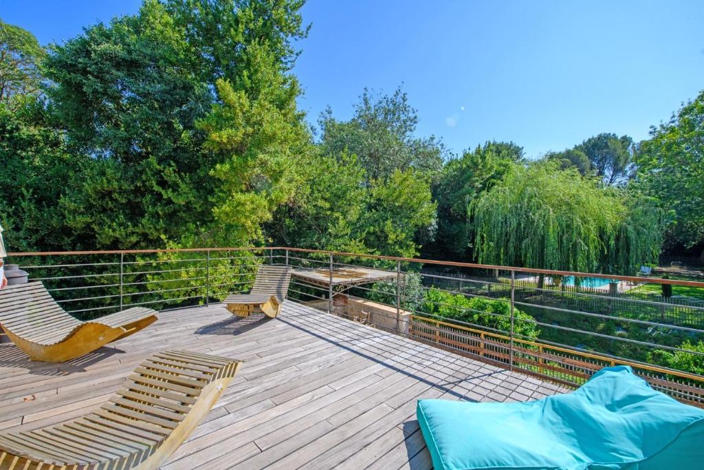 une terrasse avec deux chaises, une table et des arbres dans l'établissement Mas Gaffet, à Saint-Rémy-de-Provence