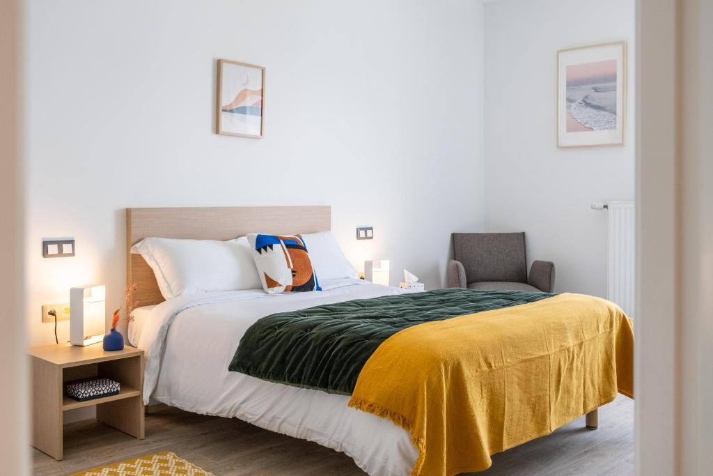 une chambre avec un grand lit et une chaise dans l'établissement Oh Activ Salon-de-Provence, à Salon-de-Provence