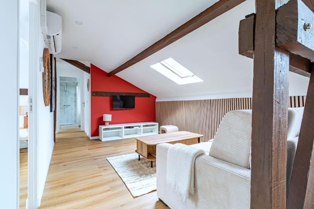 un salon avec un mur d'accent rouge dans l'établissement Appartement proche Paris 13ème arrondissement - II, à Ivry-sur-Seine