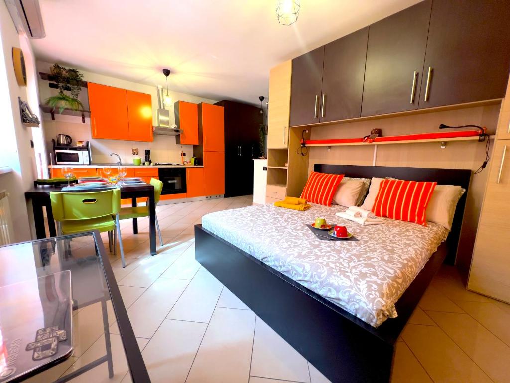 ein Schlafzimmer mit einem Bett und eine Küche mit orangefarbenen Schränken in der Unterkunft ZenHouse - Nel cuore del centro storico di Torino in Turin