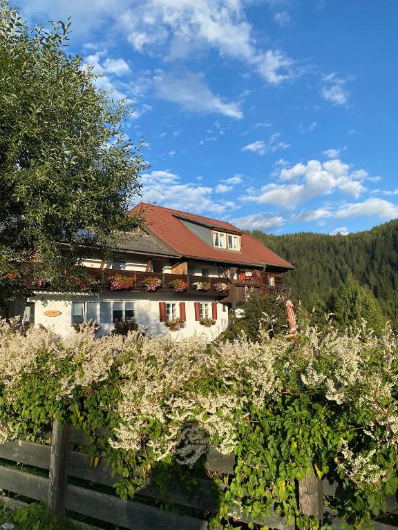 ein Haus in den Bergen mit einem Zaun und Bäumen in der Unterkunft Haus Mauken - Appartments mit Panoramablick in Murau