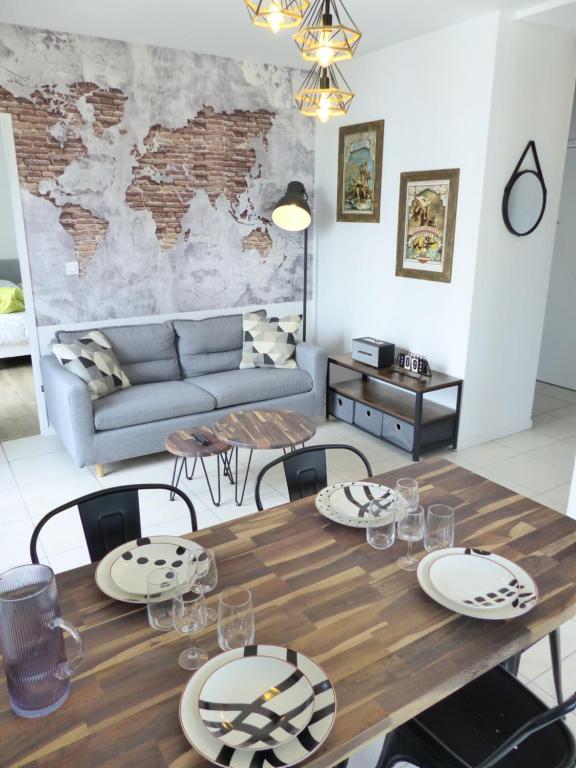 un salon avec une table et un canapé dans l'établissement Le patio'nnément-T3-Parking, à Nantes