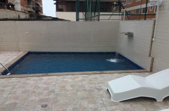 a swimming pool with a fountain in a building at Apartamento com piscina! in Samaritá