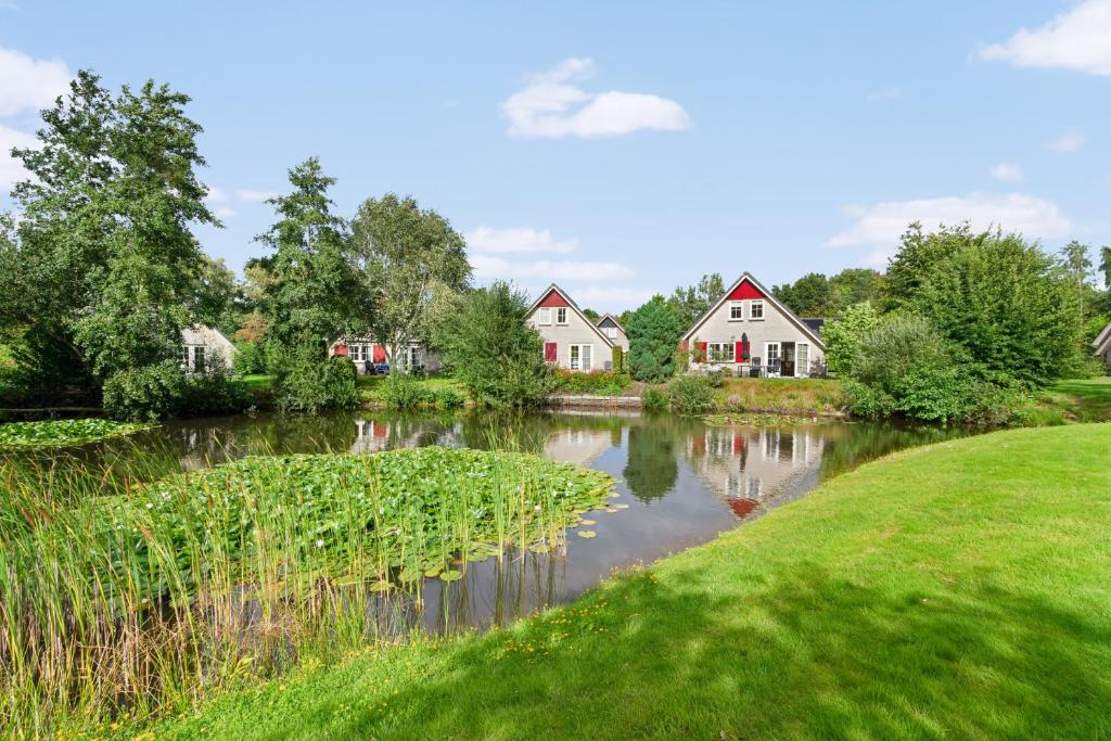 a river with houses in the middle of a village at Vakantiepark Drentse Vennen in Een-West