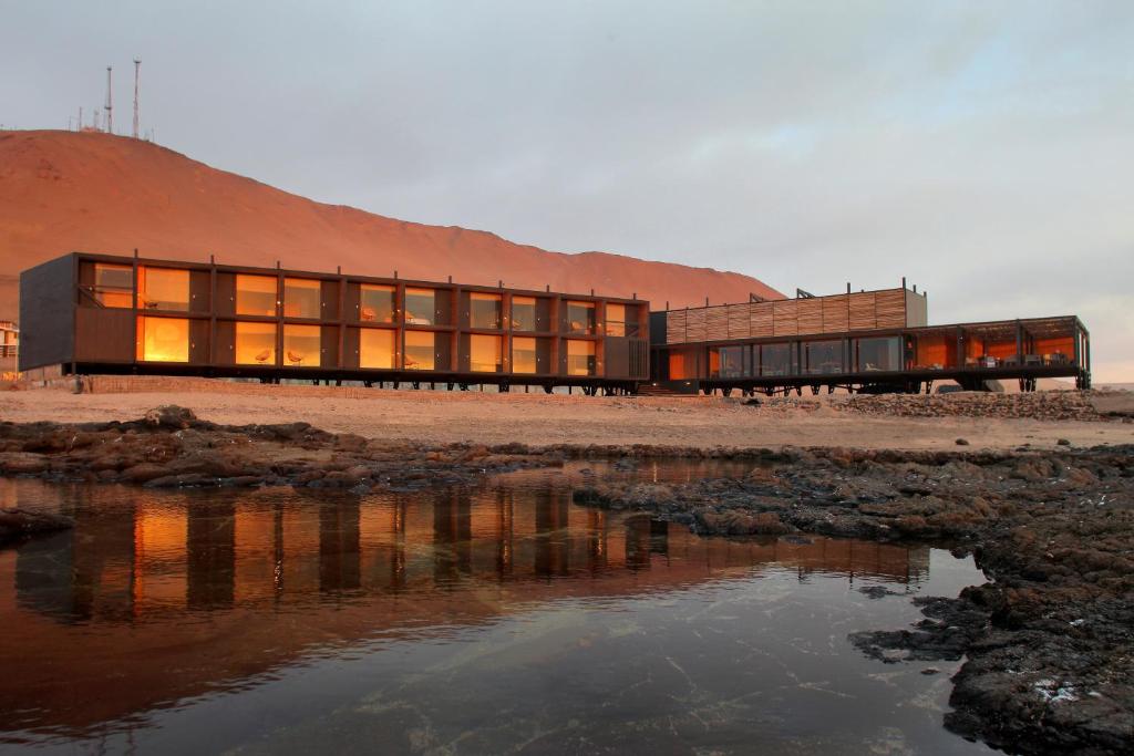 a building on the shore of a body of water at Hotel Apacheta in Arica