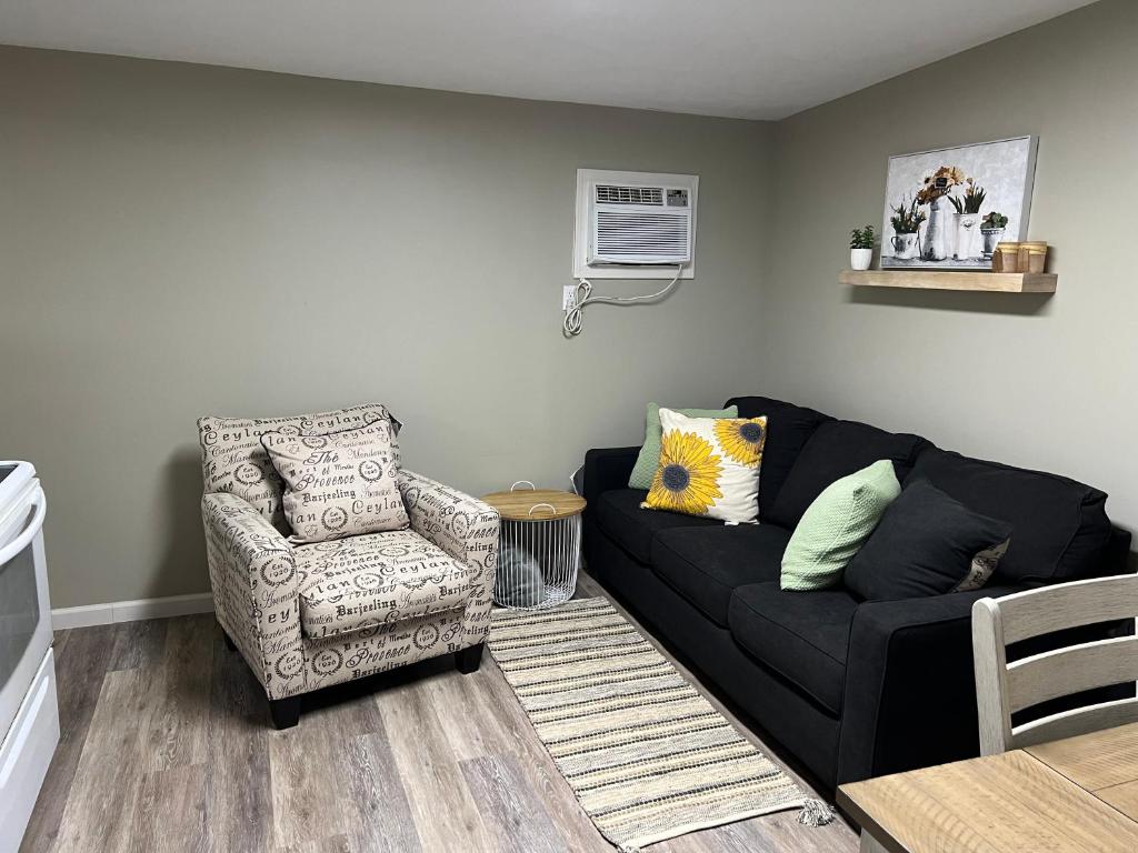 un soggiorno con divano nero e sedia di Cottage on Charles a Roxboro