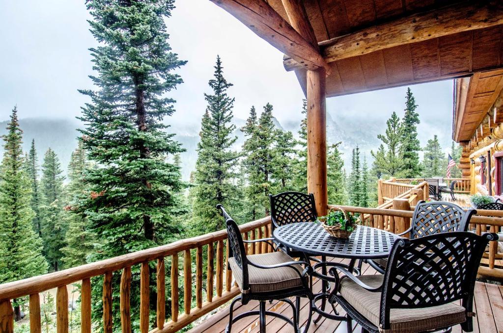 a porch with four chairs and a table on a deck at The Silver Lake Lodge - Adults Only in Idaho Springs