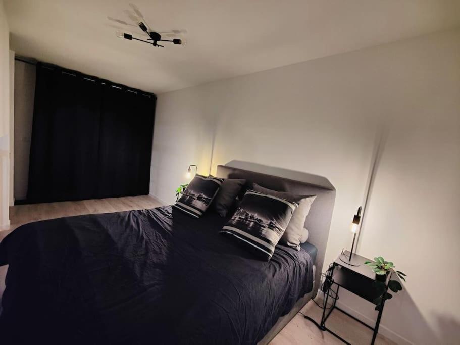 - une chambre dotée d'un grand lit avec des draps et des oreillers noirs dans l'établissement Logement calme et agréable Privé et non partagé, à Groslay