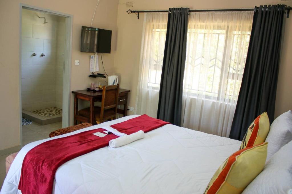 ein Schlafzimmer mit einem Bett mit zwei Handtüchern darauf in der Unterkunft Lulu Guest Lodge, Low-Density Suburbs, Victoria Falls in Victoriafälle