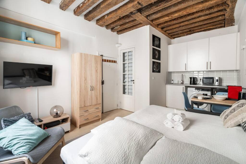 une chambre avec un lit et une cuisine dans l'établissement Studio en plein Coeur du Marais, à Paris