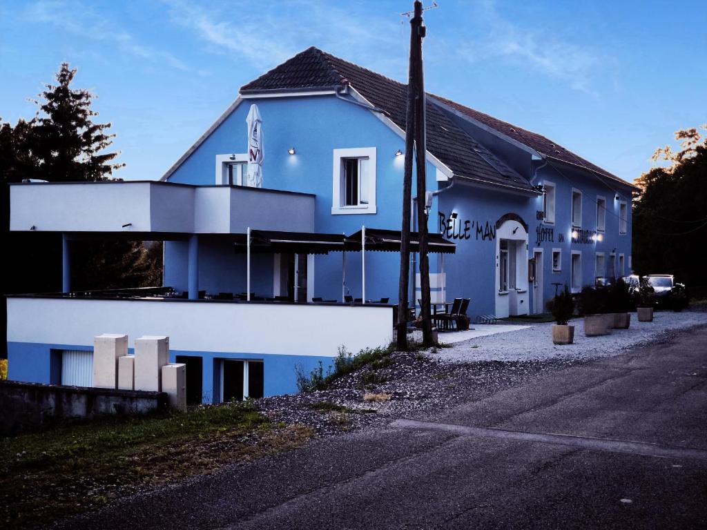 un bâtiment blanc avec une croix sur le côté d'une rue dans l'établissement belle man, à Longevelle-sur-Doubs
