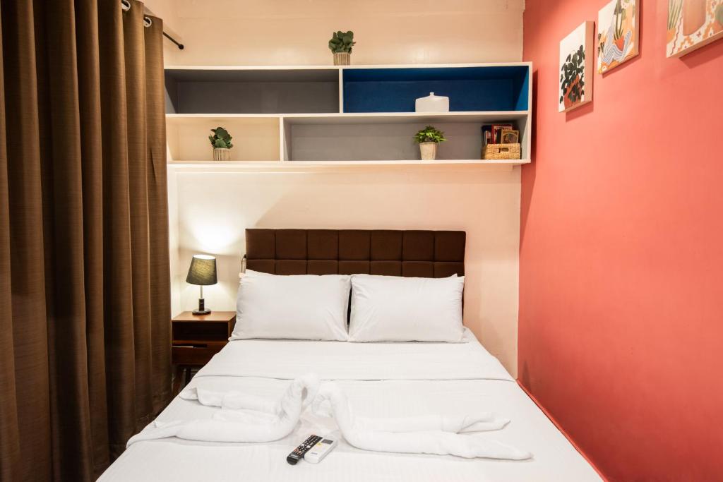 a bedroom with a bed with white towels on it at Homey and Cozey Poblacion Makati S02 in Manila
