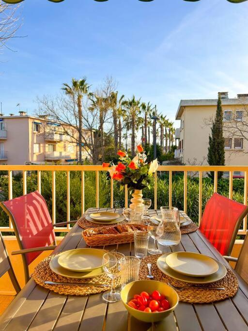 une table avec des assiettes et des bols de nourriture sur un balcon dans l'établissement Joli T2 à deux pas des plages Six-Fours Sanary, à Sanary-sur-Mer