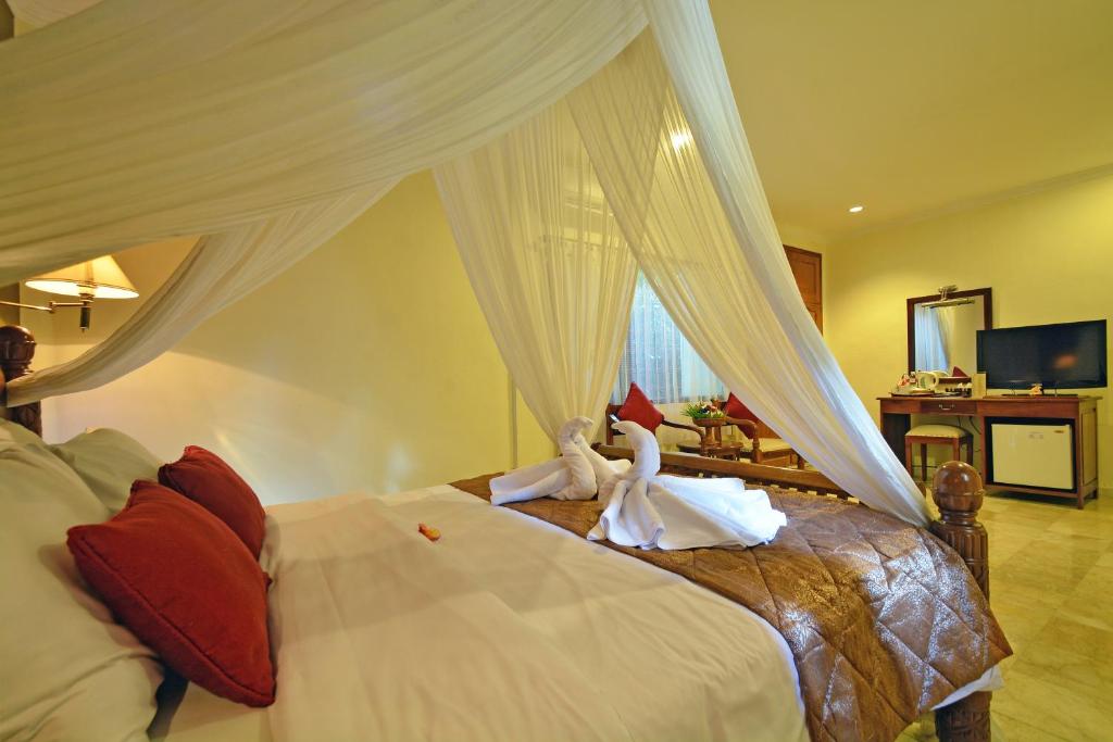 Postel nebo postele na pokoji v ubytování Puri Dewa Bharata Hotel & Villas