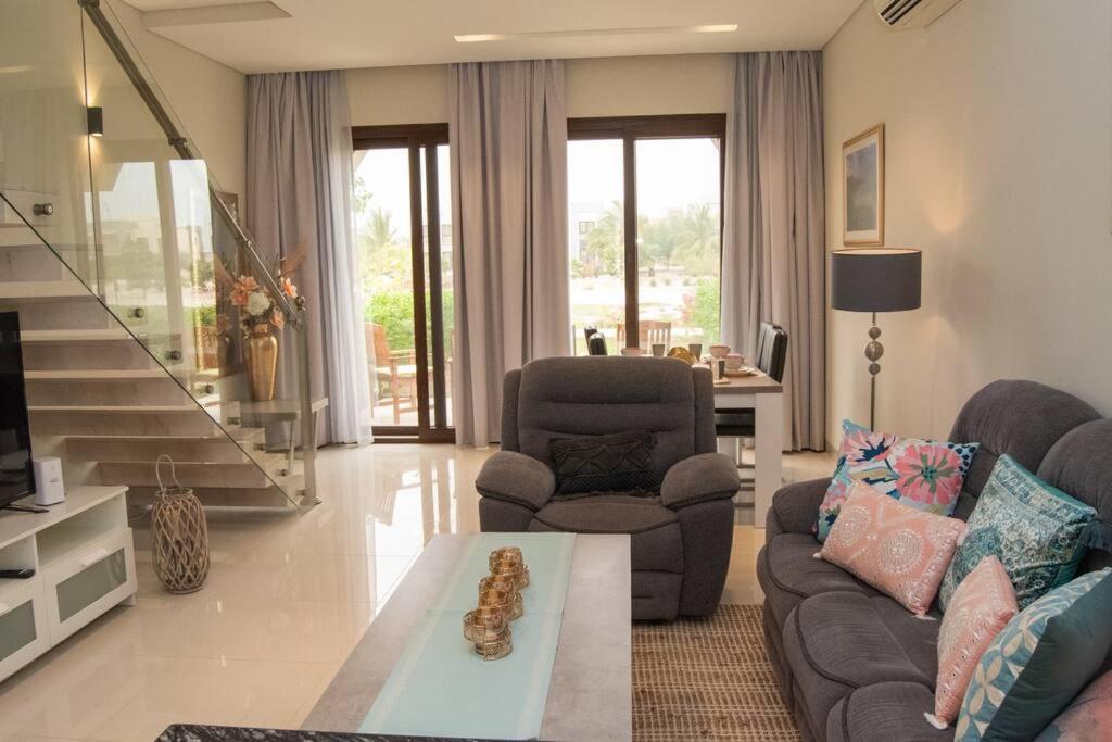 a living room with a couch and a table at Stylish Townhouse Retreat in the Heart of Salalah by Bespoke Holiday Homes in Wādī Khasbar