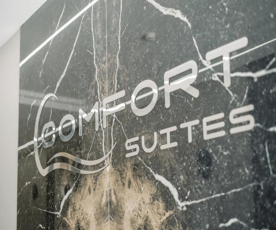 a sign with the words comfort suites on a marble wall at Comfort Suites in Golem