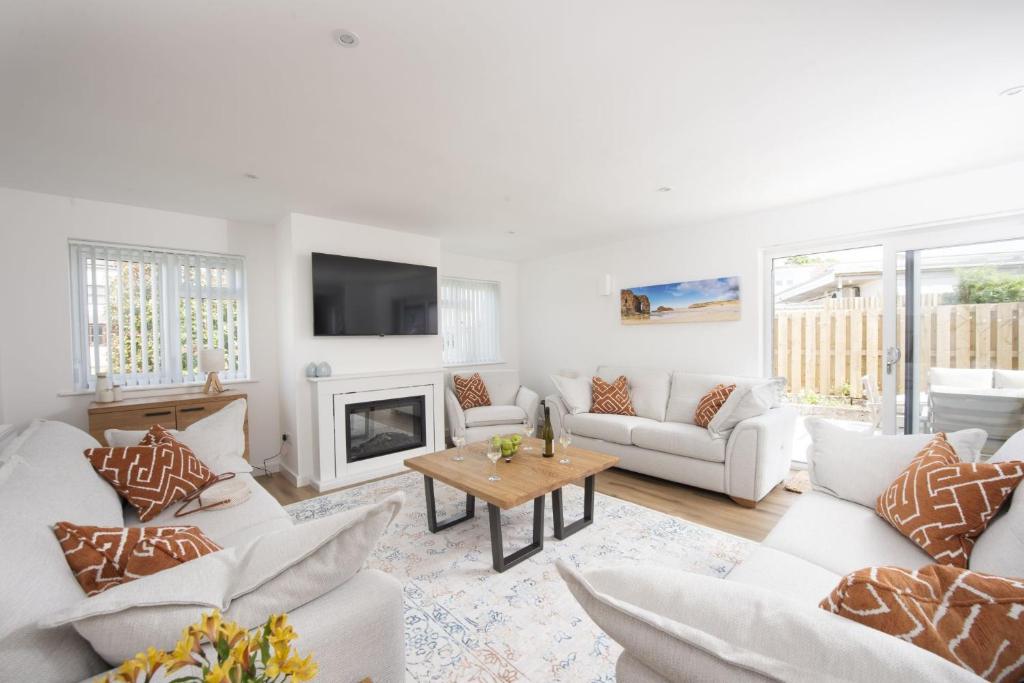 a living room with white furniture and a fireplace at Tre Lowen, Goonhavern, Perranporth - Free Parking - Free Wifi - Games Room in Perranporth