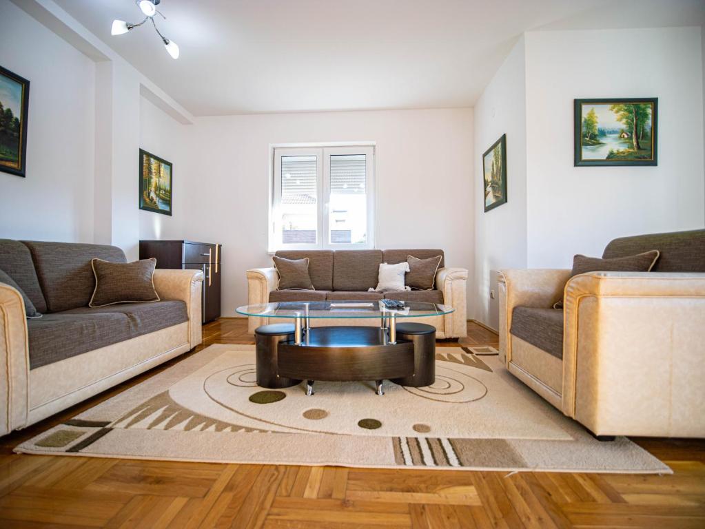 a living room with two couches and a coffee table at Apartman Casa di Tasa in Veliko Gradište
