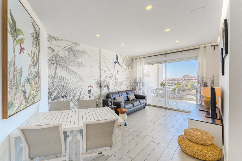 ein Wohnzimmer mit einem Tisch und einem Sofa in der Unterkunft Ocean Garden Sunset View in Adeje
