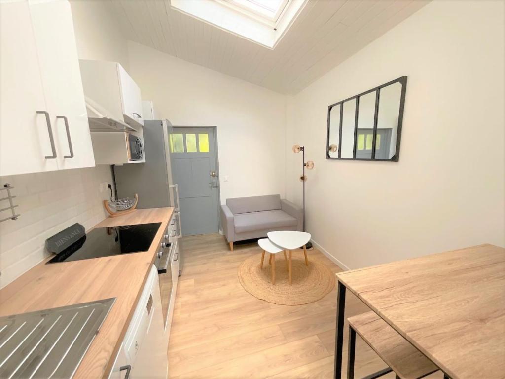 Il comprend une cuisine et un salon avec une table et une chaise. dans l'établissement T3 plein centre proche Versailles Saint Quentin en Yvelines, à Voisins-le-Bretonneux