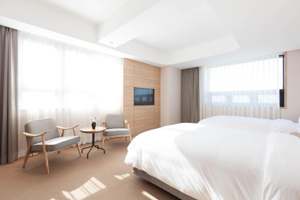 a bedroom with a bed and two chairs and a table at Acube Hotel Dongdaemun in Seoul