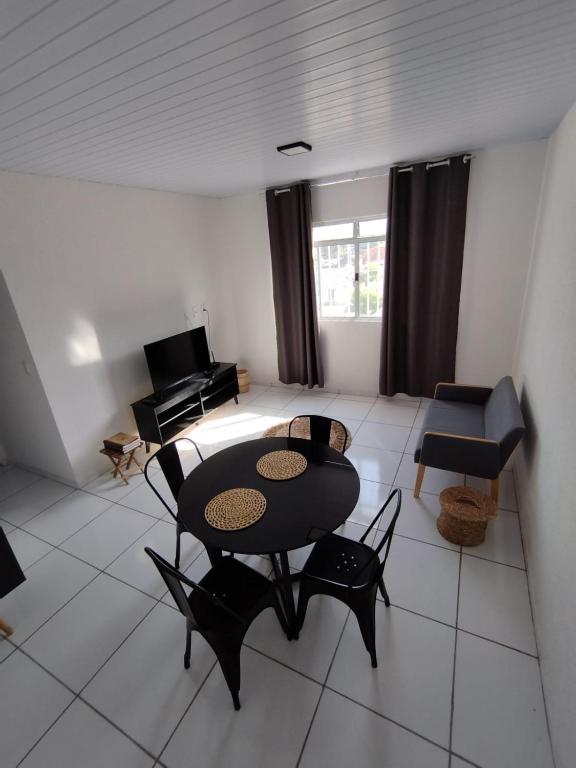 a living room with a table and chairs and a couch at Loft aconchegante ao lado do Rio Poty Shopping in Teresina
