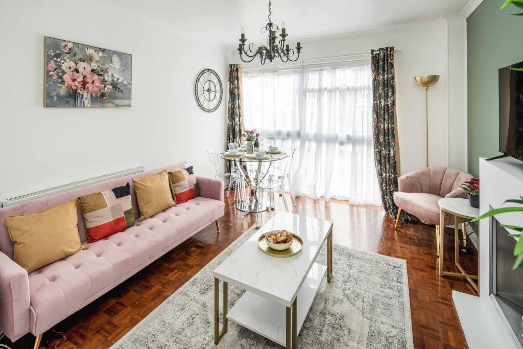 クロイドンにあるChatsworth Ground Floor Apartment!のリビングルーム(ピンクのソファ、テーブル付)