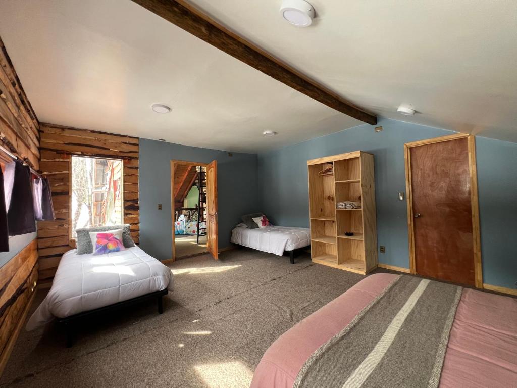 a bedroom with two beds and blue walls at Oceana Suites Hotel Volkano in Malalcahuello
